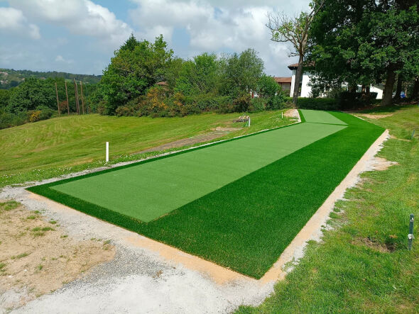 Atlanta Outdoor tee line consisting of one continuous green synthetic grass strip surrounded by trees